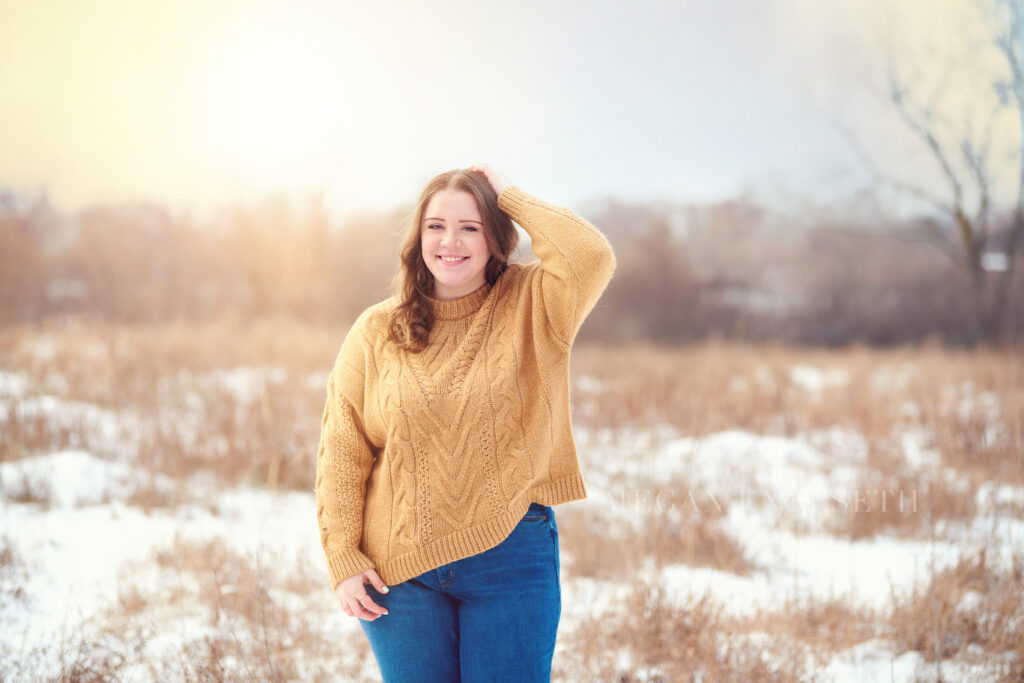senior portrait in the snow with yellow sweater