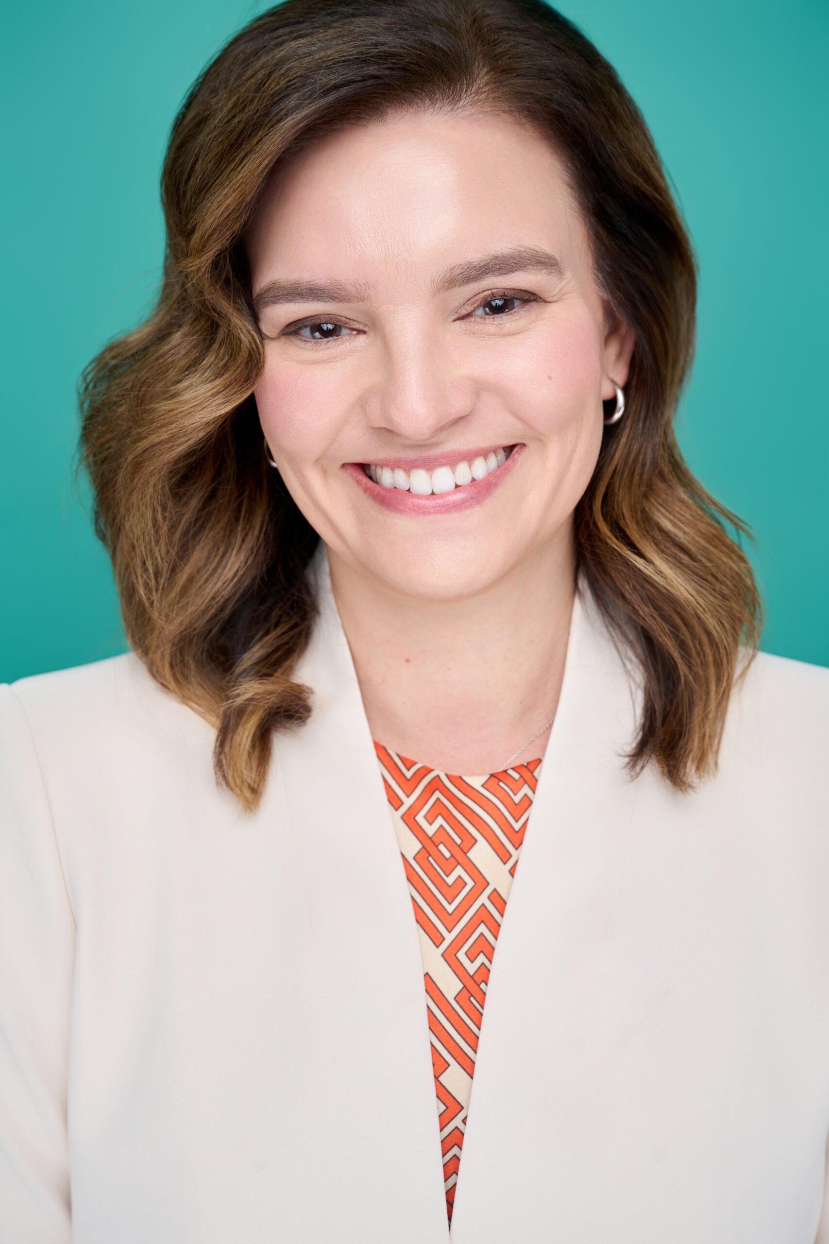 Smiling individual posing professionally with teal background, exemplifying confidence and approachability. Ideal for professional profiles like CEOs, lawyers, or doctors. Suitable for corporate, medical, or legal industries.