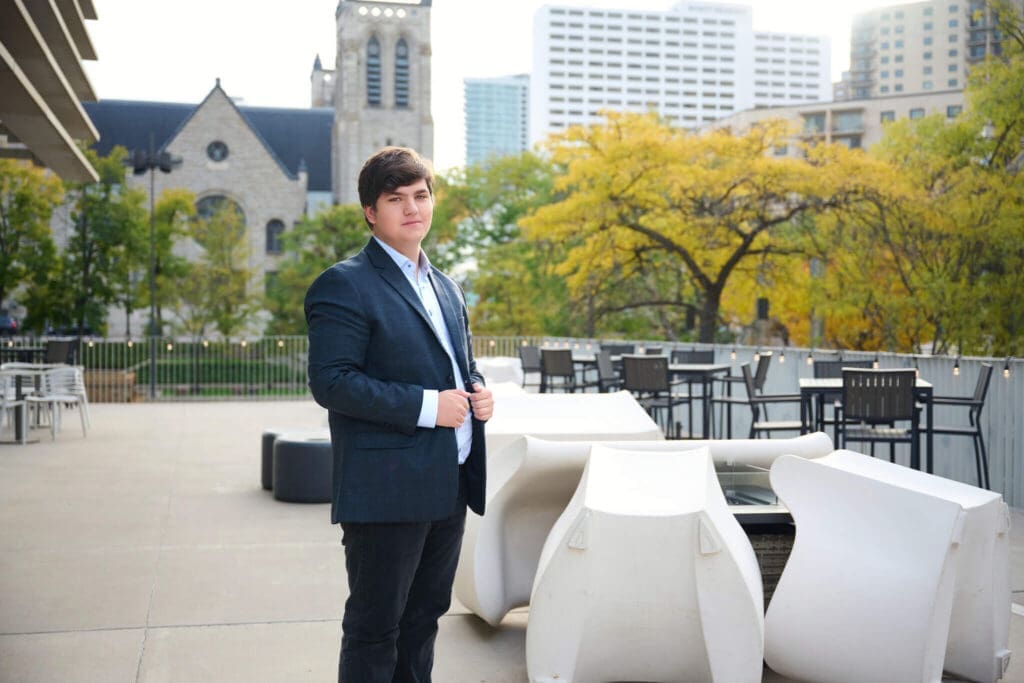 Senior picture of guy from Woodbury High School posing in front of city skyline for Megan Engeseth Photographer